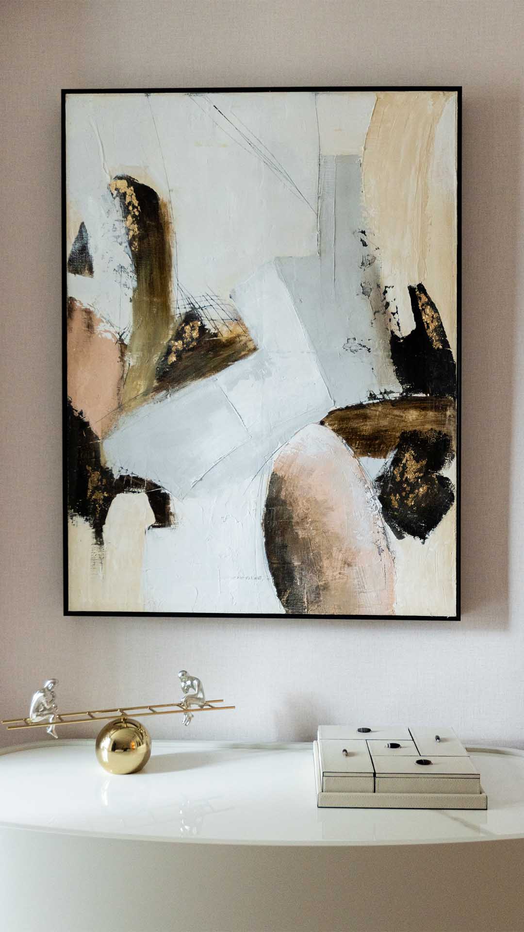 Modern abstract art and decorative objects on a console table, highlighting the interior design impact on a rental flat