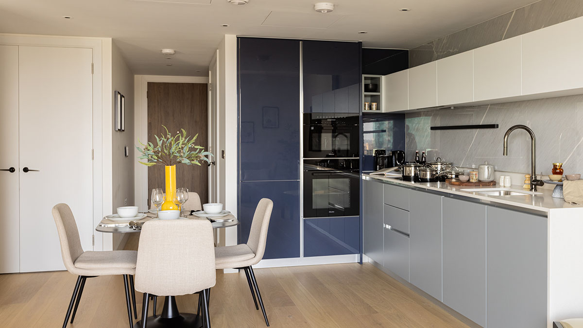 Sleek, modern London flat kitchen with blue and grey cabinets, part of a furnishing package for overseas investors
