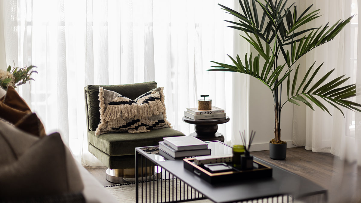 Modern living room with stylish accent chair and a large plant, a successful staging transformation for a flat