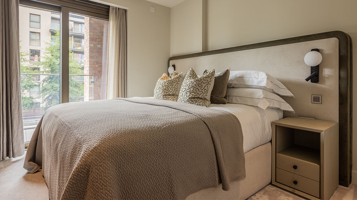 Holiday home bedroom interior design with bespoke bed and soft neutral tones in London