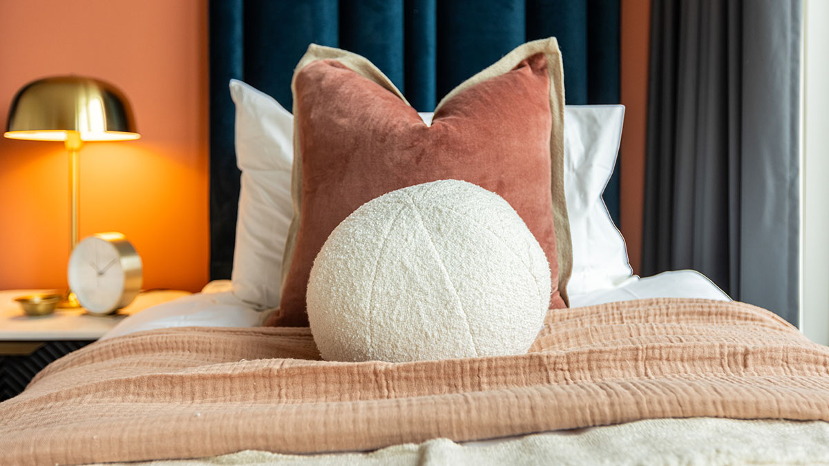 Vibrant terracotta bedroom transformation for London flat, highlighting premium furnishing packages for investors.