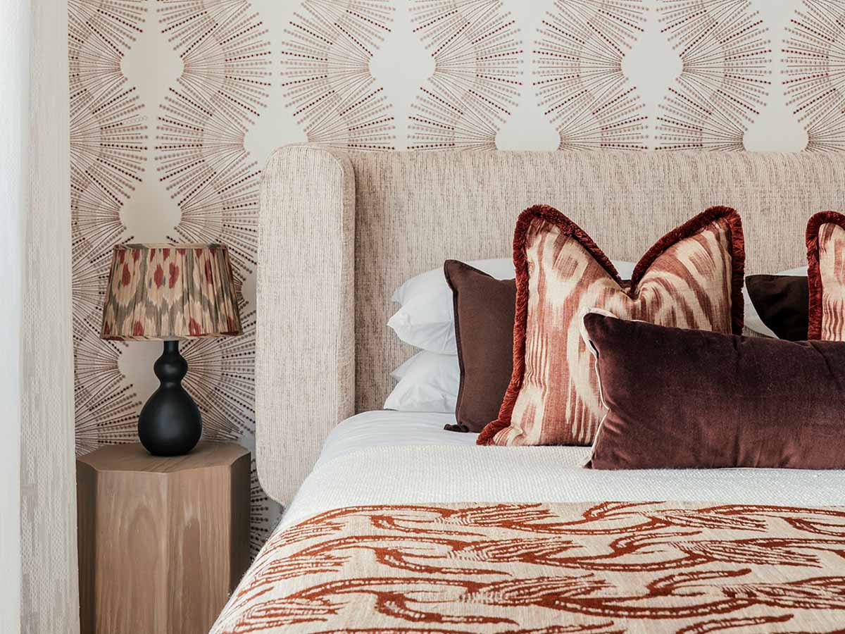 Close-up of interior styling by InStyle Direct featuring a textured burnt orange fringed cushion and a leopard print velvet pillow on a neutral sofa