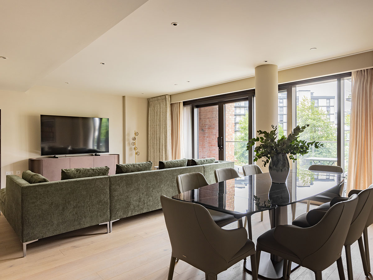 Wide view of a professionally staged open-plan living and dining area in a London flat.