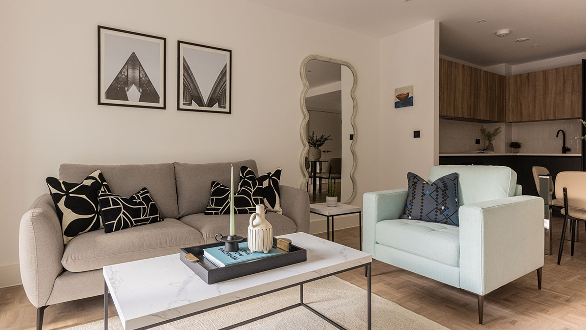 Modern living room interior design at Cavendish House Beaufort Park London with neutral sofa, accent chair and contemporary decor