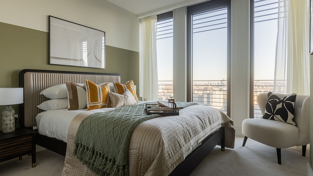 Modern furnished bedroom with large windows and city skyline view at One Bishopsgate Plaza London