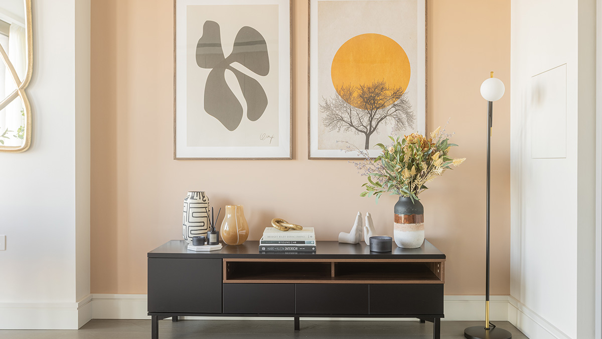 Stylish console table with decorative accessories, abstract wall art and floor lamp in a modern London apartment at One Bishopsgate Plaza