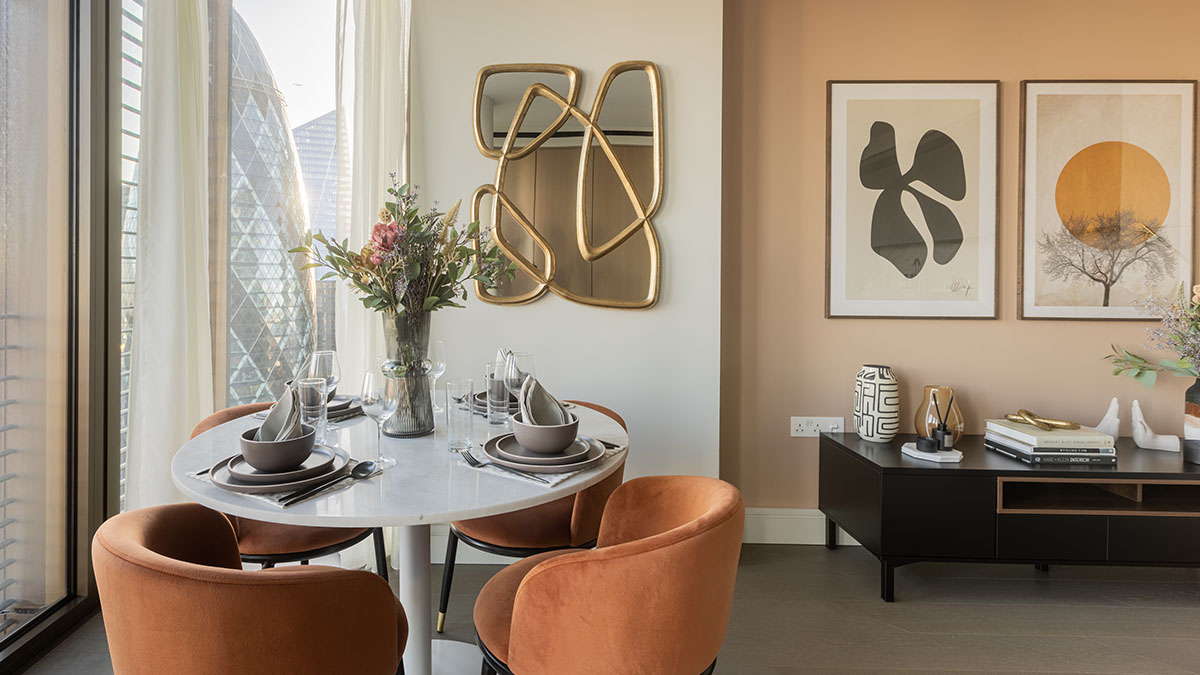 Modern dining area with marble table, velvet chairs, abstract wall art, and city skyline view