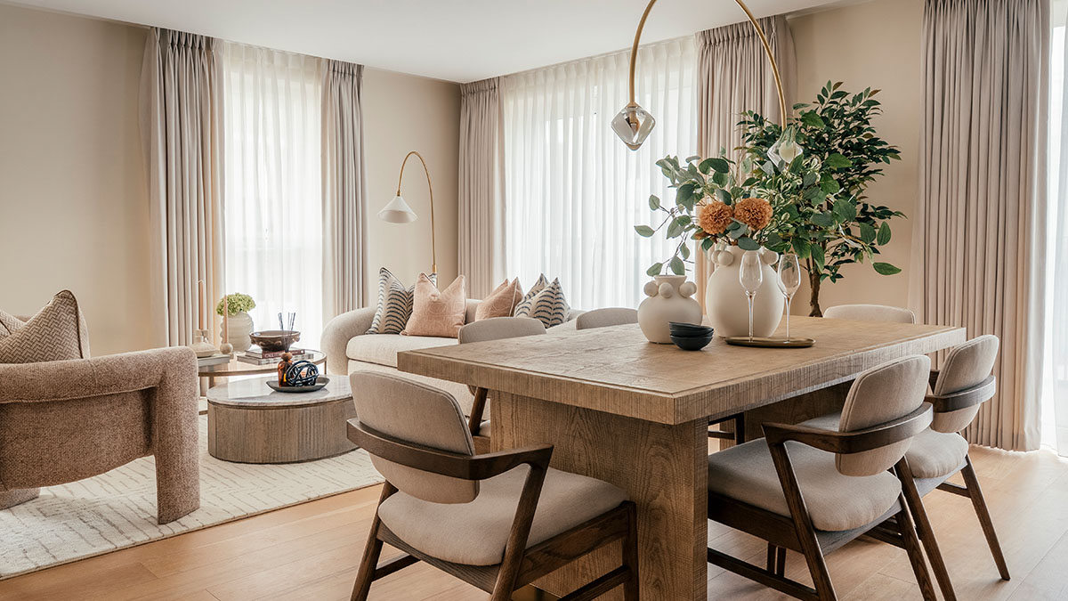 Stylish open-plan living and dining area with wooden table, upholstered chairs, soft neutral tones, large windows, and elegant home décor