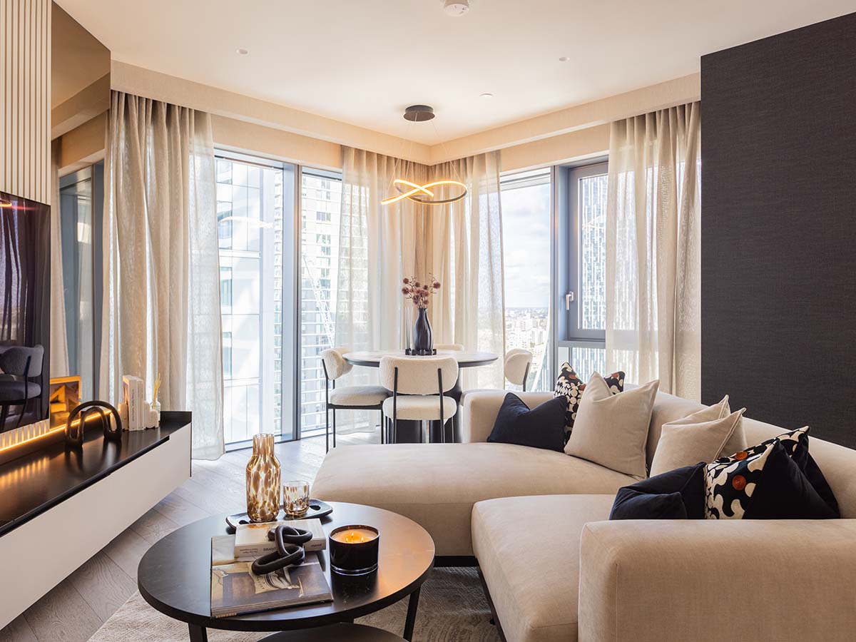 A contemporary living area styled by InStyle Direct featuring a deep teal panelled feature wall, a vibrant mustard yellow velvet swivel armchair, and a minimalist black media console displaying curated decor in London.