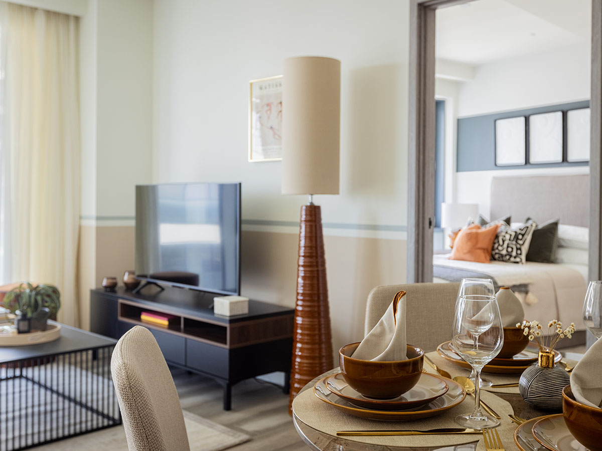 A designer dining area furniture package by InStyle Direct featuring a circular dining table with four elegant neutral upholstered chairs, a decorative gold centerpiece, and floor-to-ceiling sheer curtains in Canary Wharf.