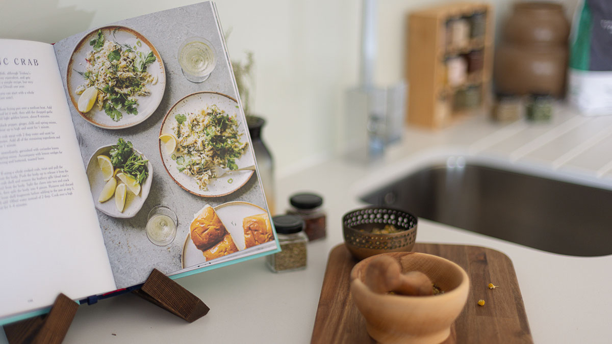 styled kitchen countertop with open cookbook, spices and wooden accessories in a modern build to rent apartment