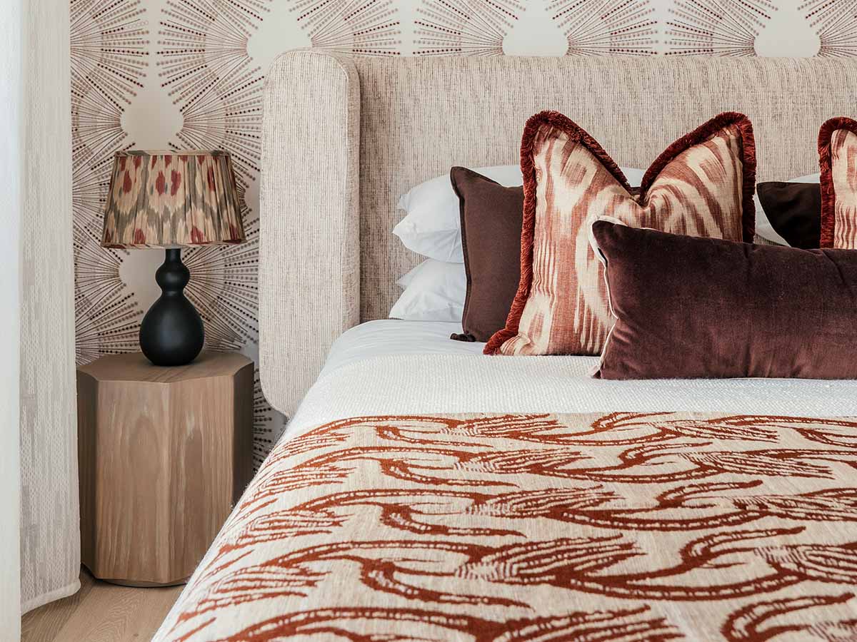 A modern dining room interior styled by InStyle Direct featuring a black circular table, contemporary chairs with geometric upholstery, and a large gold vase with fresh greenery in Westminster.