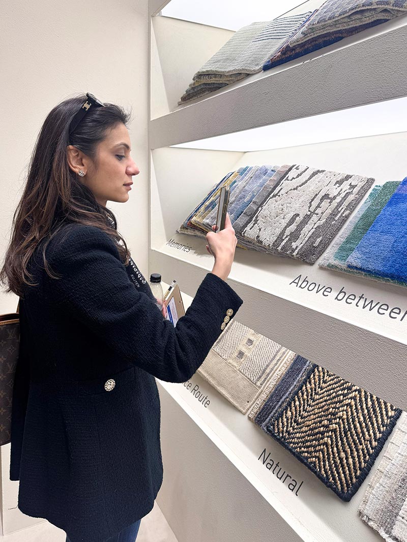Interior designer selecting fabric samples in a showroom with textured upholstery swatches on display