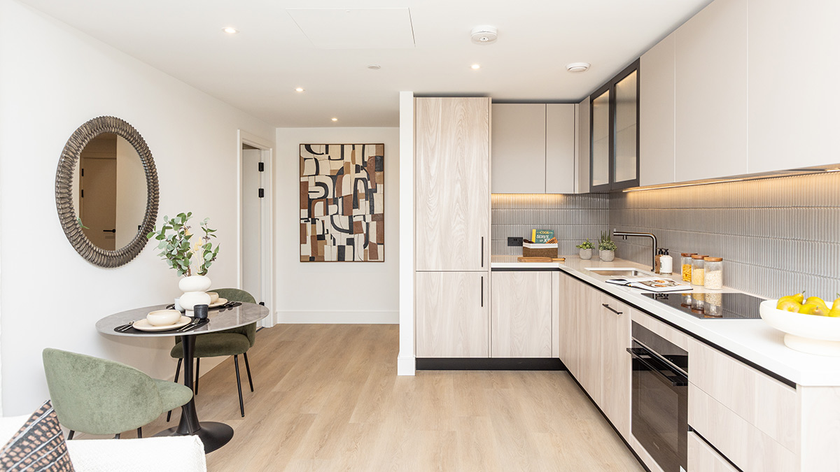 Contemporary open-plan kitchen with light wood cabinetry, dining table, and stylish modern furnishings.