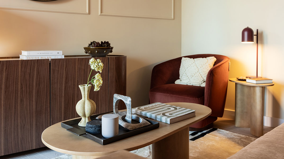 Close-up of the living room coffee table styling with decorative accessories and accent seating in a West End Gate apartment.