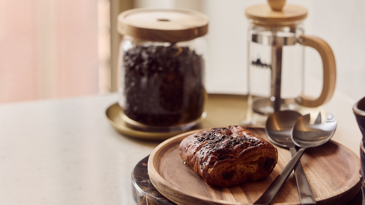 Coffee and pastries arranged on a kitchen counter in a furnished apartment