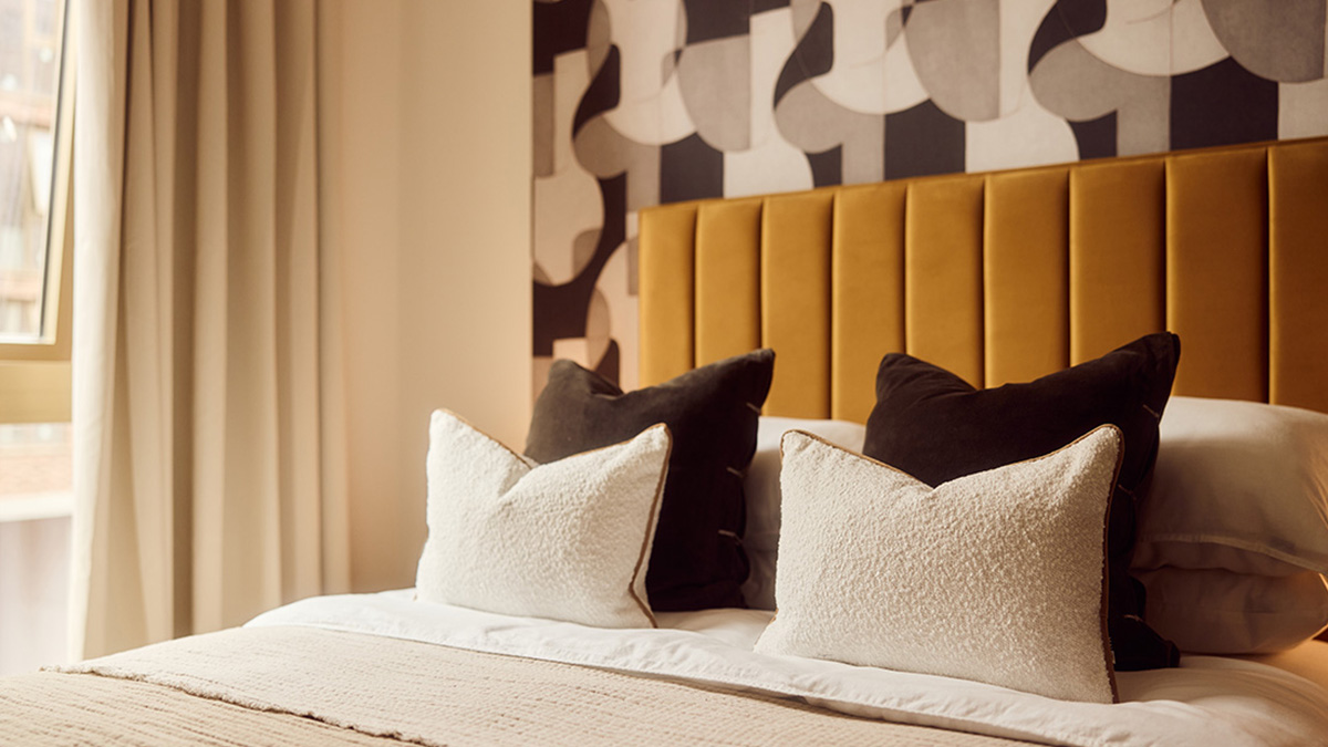 Stylish bedroom with mustard upholstered headboard and decorative cushions