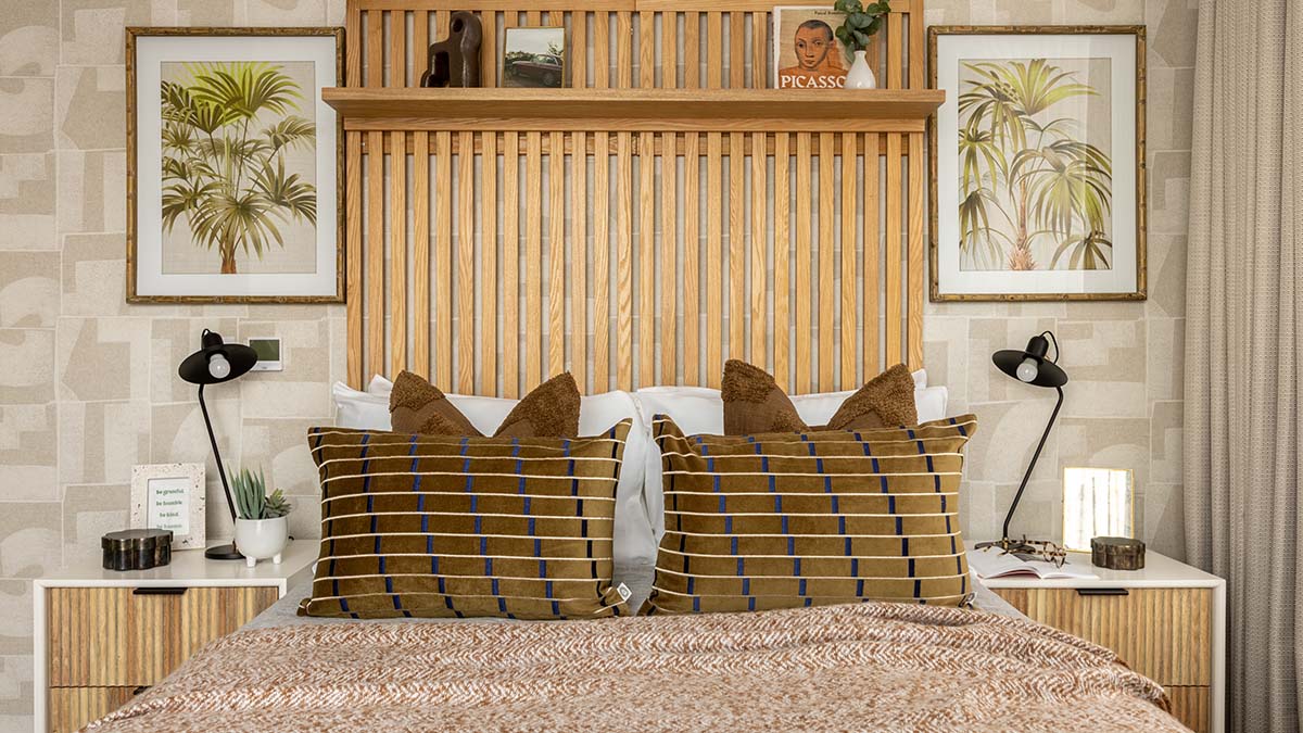 Stylish furnished bedroom in a London property featuring a statement wooden headboard, bedside tables and patterned cushions.