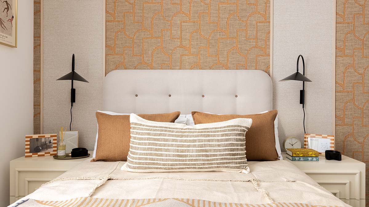 Fully furnished London property bedroom with upholstered headboard, layered bedding, bedside tables and wall lighting.
