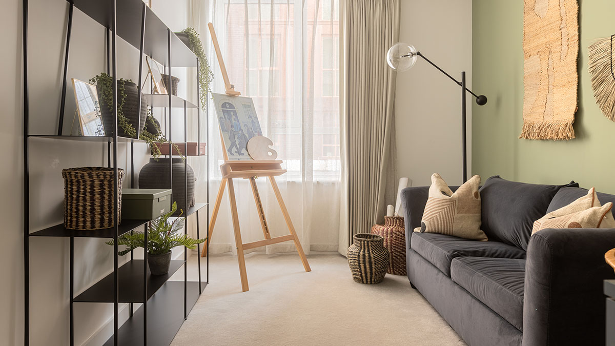 Furnished London property living space with shelving, artwork, seating and a dedicated creative workspace.