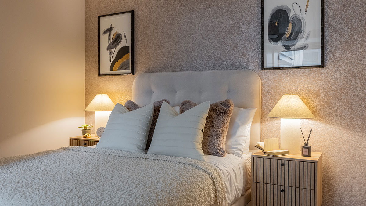 Modern furnished bedroom with upholstered bed, bedside tables and lamps